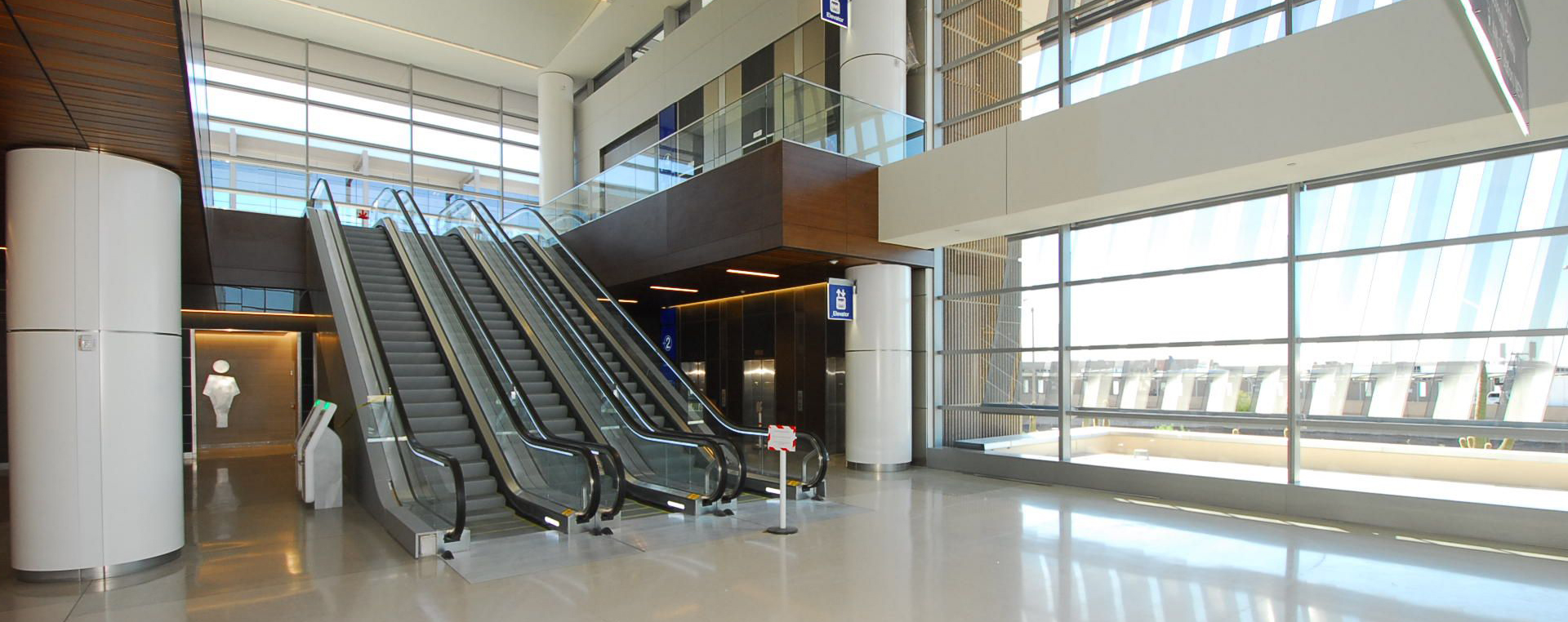A T3 escalator in Sky Harbor International Airport with large windows.