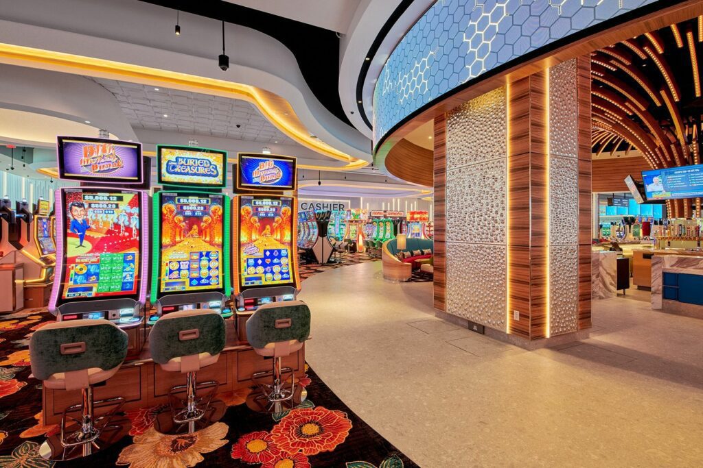 Interior of the vibrant Gila River Santan Mountain Casino, showcasing slot machines, a bar area, and gaming tables with colorful lighting and modern decor.