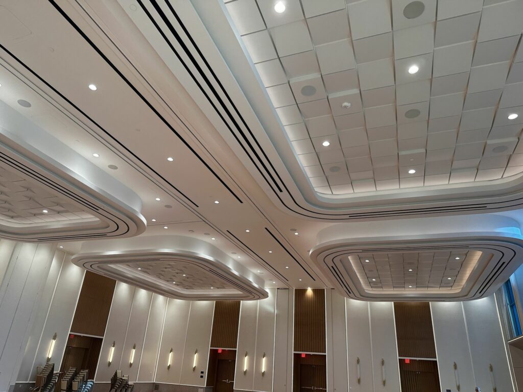 Interior of the Gila River Santan Mountain Casino conference hall, featuring curved, illuminated ceilings and rows of chairs that highlight a minimalist architectural design.