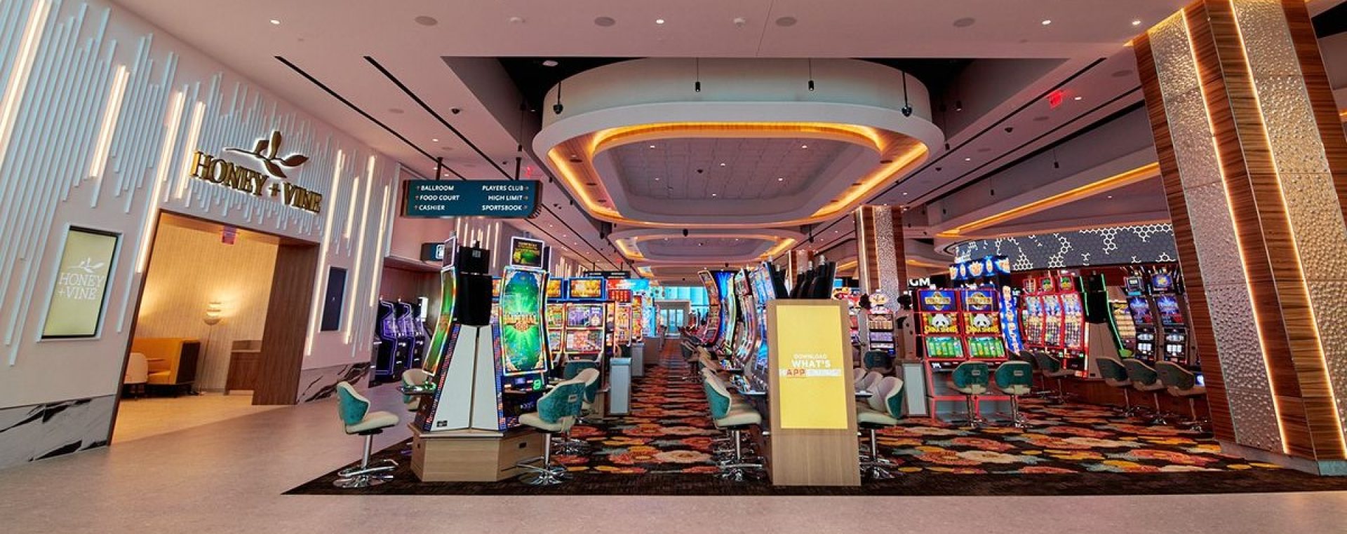 Wide-angle view of a vibrant Arizona casino interior with colorful slot machines, promotional displays, and plush seating under a modern lighting arrangement.