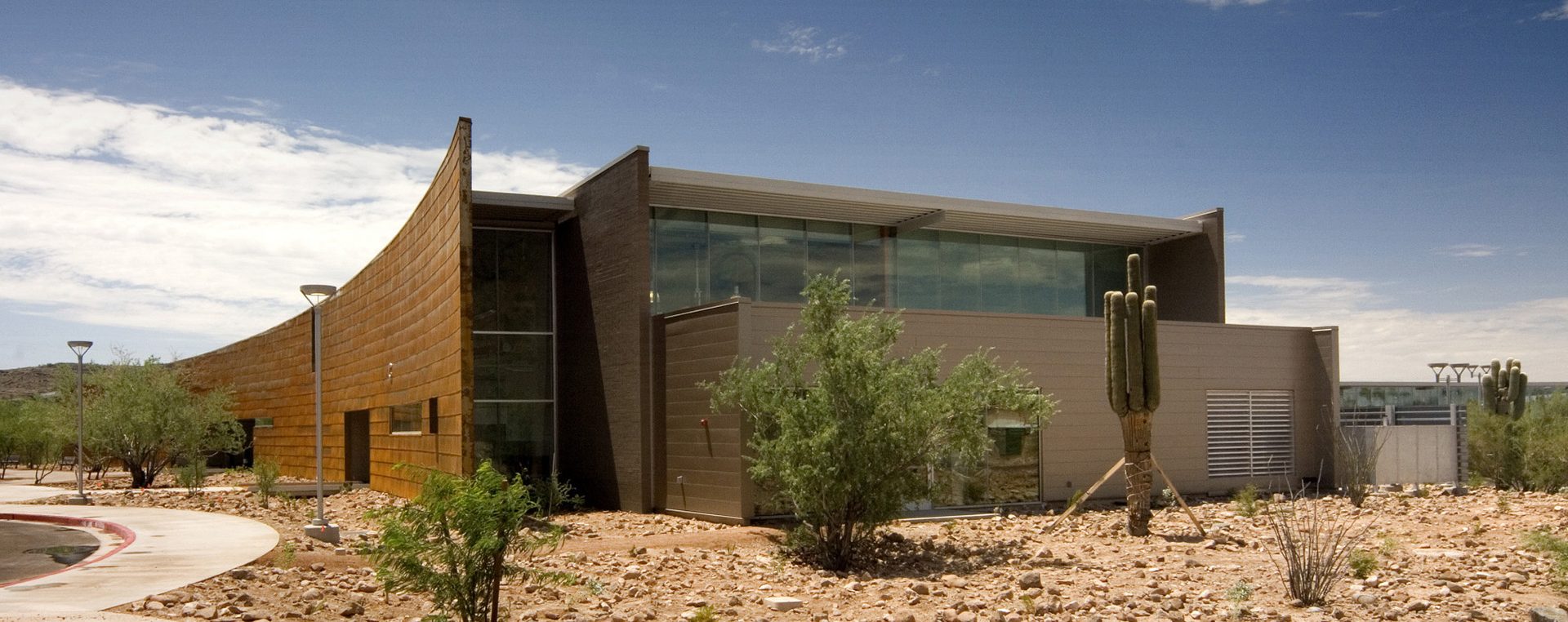 A building with rocks and cactus in the background, provided by MKB Construction Services.